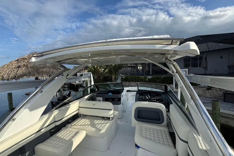  Yacht Photos Pics 2018 Cobalt 30SC boat interior with white seating and modern dashboard under a clear sky.