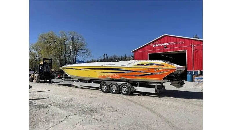  Yacht Photos Pics 2006 Fountain 42 speedboat on trailer near red building, sunny day.