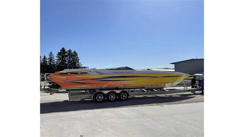  Yacht Photos Pics 2006 Fountain 42 speedboat with vibrant yellow and orange design on a trailer.