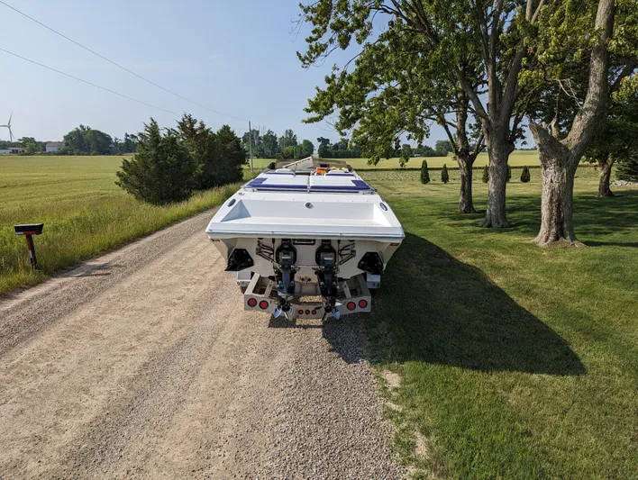  Yacht Photos Pics 2006 Fountain 42 boat on a rural dirt road, surrounded by trees and fields.