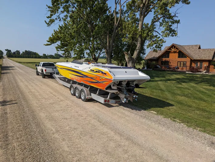  Yacht Photos Pics A 2006 Fountain 42 speedboat on a trailer, parked on a rural gravel road.