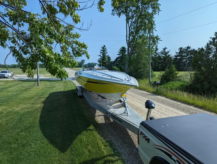  Yacht Photos Pics A 2006 Fountain 42 boat on a trailer, parked on a grassy roadside.