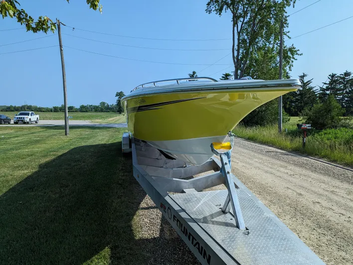  Yacht Photos Pics 2006 Fountain 42 boat on trailer, parked on a rural road with trees and grass.