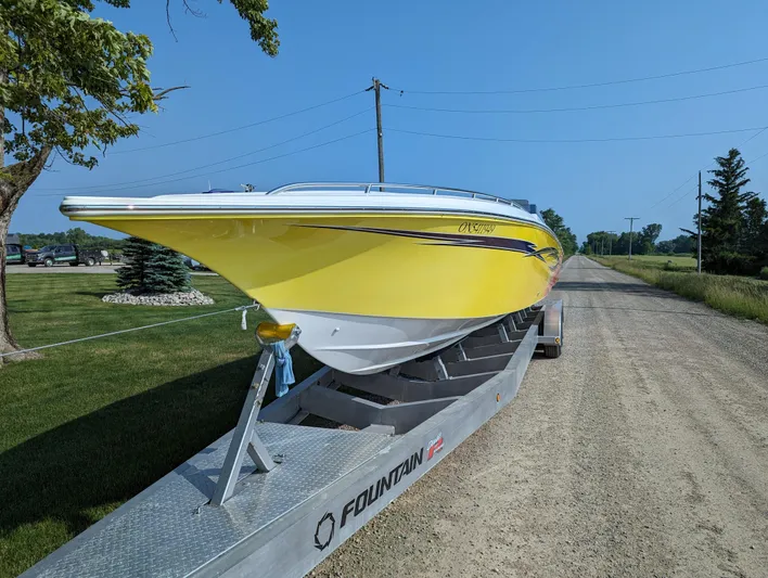  Yacht Photos Pics Yellow 2006 Fountain 42 boat on trailer, parked on rural road.