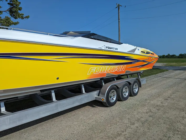  Yacht Photos Pics 2006 Fountain 42 speedboat with vibrant yellow and orange design on a trailer.