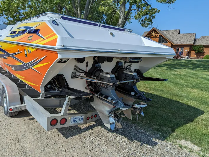  Yacht Photos Pics 2006 Fountain 42 boat with vibrant orange graphics on a trailer, parked on grass.