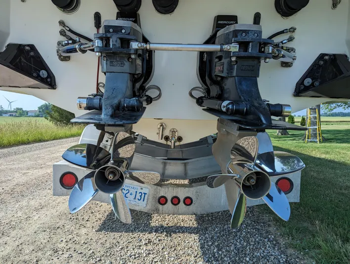  Yacht Photos Pics Twin propellers on a 2006 Fountain 42 boat, parked on a gravel path.