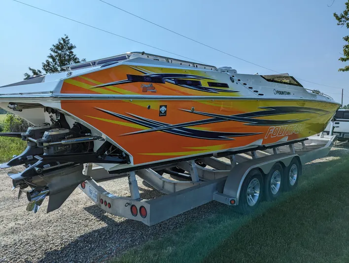  Yacht Photos Pics 2006 Fountain 42 speedboat with vibrant orange and yellow graphics on a trailer.