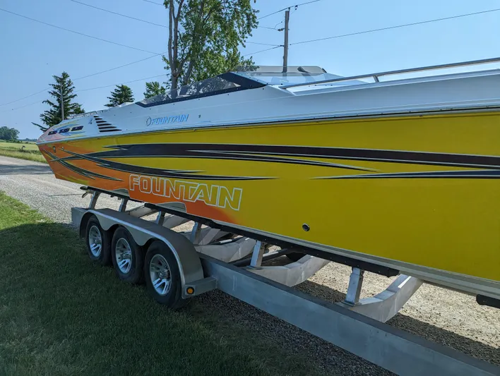  Yacht Photos Pics Yellow 2006 Fountain 42 speedboat on trailer, parked outdoors.