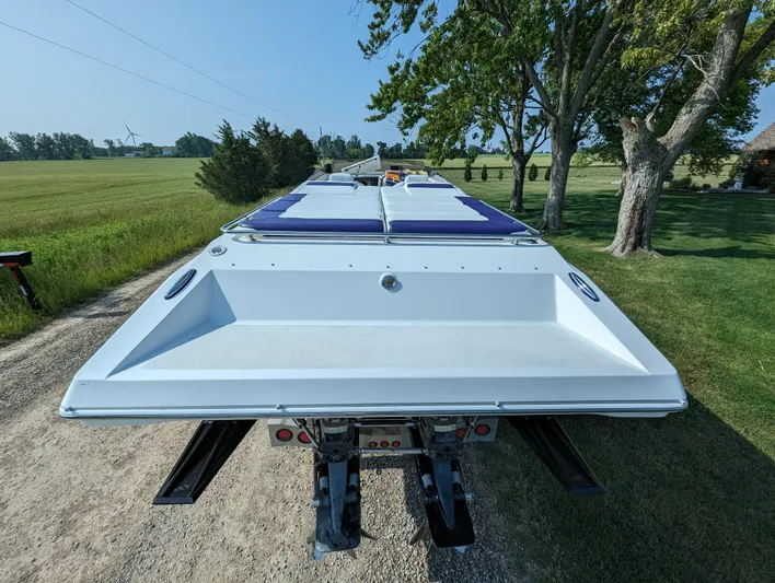  Yacht Photos Pics 2006 Fountain 42 boat on trailer, parked on rural road with trees and fields.