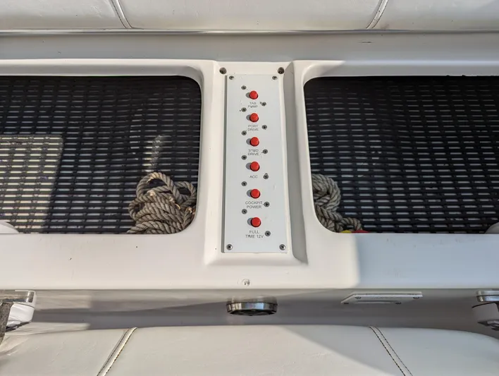  Yacht Photos Pics Control panel on a 2006 Fountain 42 boat with red buttons and storage compartments.