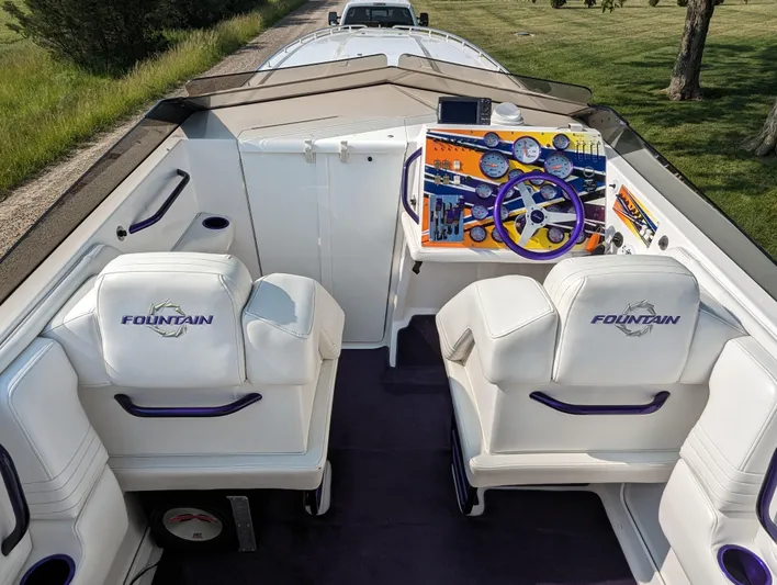  Yacht Photos Pics 2006 Fountain 42 boat interior with white seats, vibrant dashboard, and steering wheel.