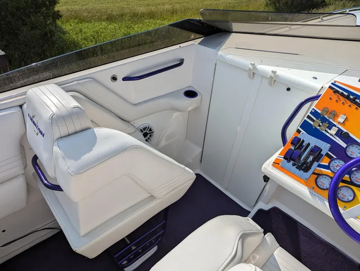  Yacht Photos Pics Interior of a 2006 Fountain 42 boat with white seating and colorful dashboard controls.
