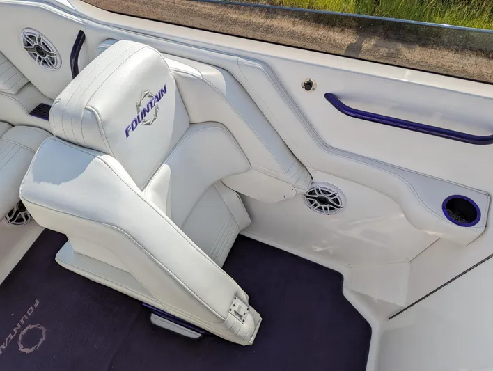  Yacht Photos Pics White leather seat in a 2006 Fountain 42 boat, featuring built-in speakers and cup holder.