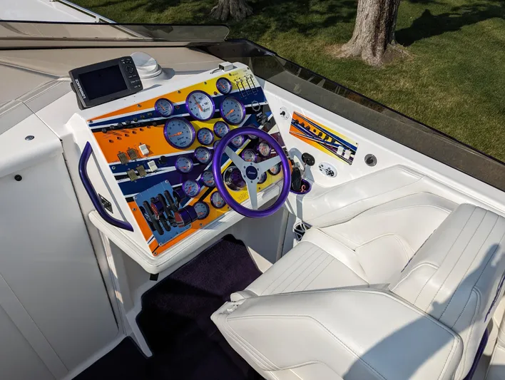  Yacht Photos Pics Cockpit of 2006 Fountain 42 boat with colorful dashboard and white seating.