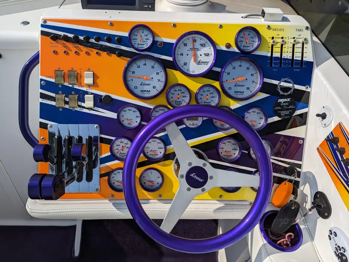  Yacht Photos Pics Colorful boat dashboard with gauges and controls, featuring a purple steering wheel. Fountain 42, 2006 model.