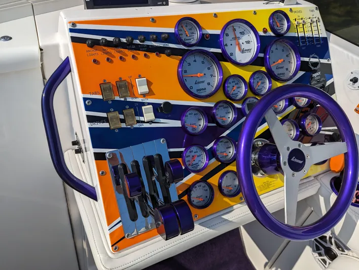  Yacht Photos Pics Colorful control panel of a 2006 Fountain 42 boat with gauges and steering wheel.