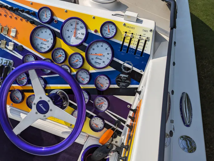  Yacht Photos Pics Dashboard of a 2006 Fountain 42 boat with colorful gauges and a purple steering wheel.