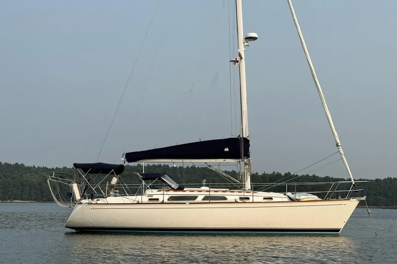 Souwester Yacht Photos Pics 2003 Sabre 362 sailboat on calm water with forested background.
