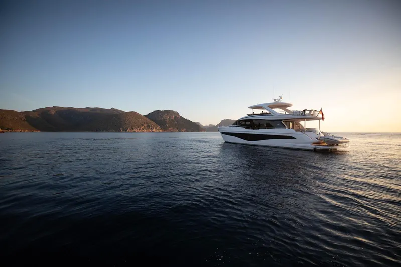  Yacht Photos Pics Luxurious 2024 Princess Y80 yacht cruising at sunset near scenic coastline.