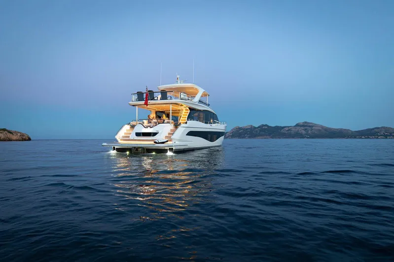  Yacht Photos Pics Luxurious 2024 Princess Y80 yacht cruising at sunset near scenic coastline.