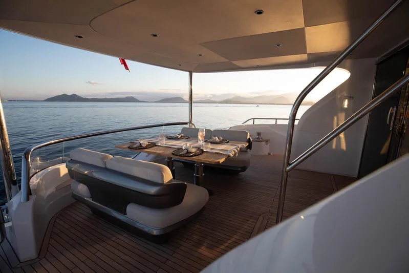 Yacht Photos Pics Luxurious 2024 Princess Y80 yacht deck with elegant dining setup at sunset.