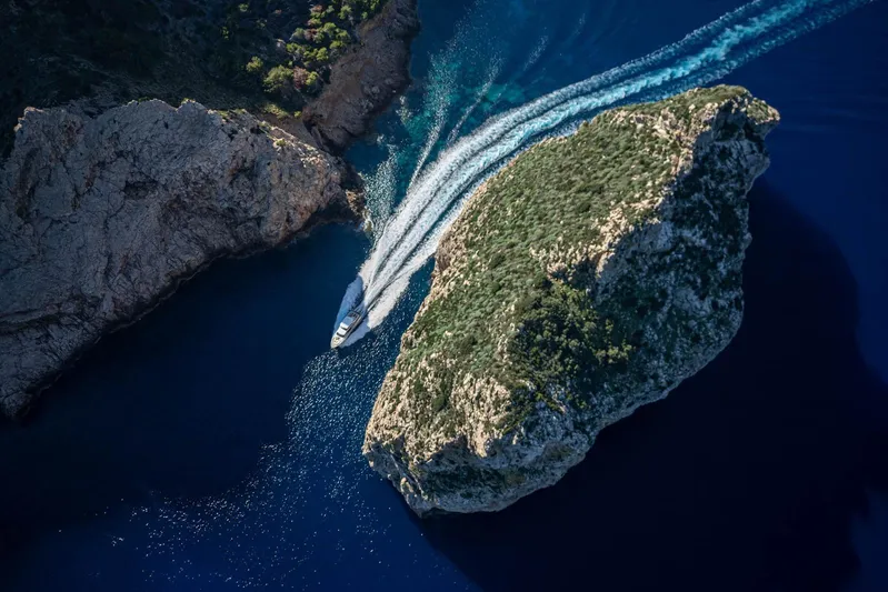  Yacht Photos Pics Aerial view of 2024 Princess Y80 yacht navigating between rocky cliffs.
