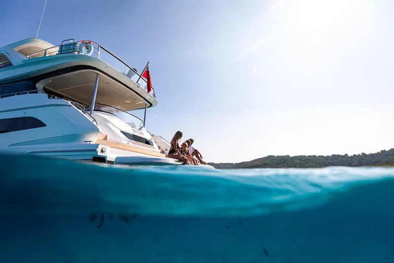  Yacht Photos Pics Luxury Princess Y80 yacht, 2024 model, with people relaxing on deck, clear blue water.