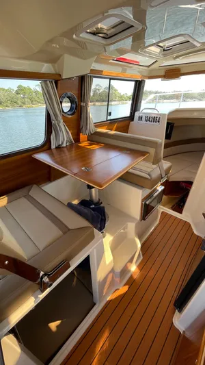  Yacht Photos Pics 2022 Ranger Tugs R-25 interior with wood accents and seating, overlooking water.