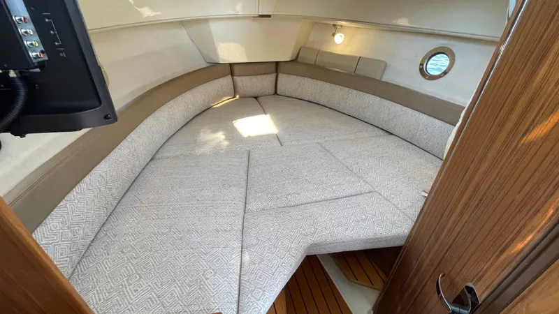  Yacht Photos Pics 2022 Ranger Tugs R-25 cabin interior with cushioned seating and wooden accents.