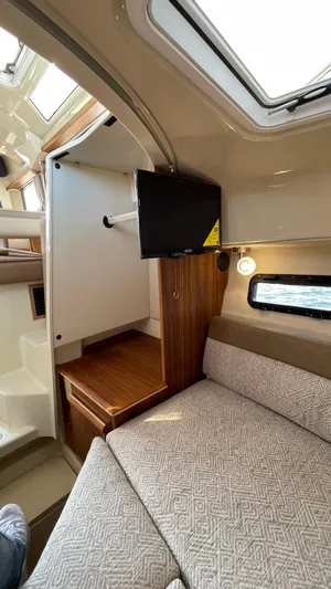  Yacht Photos Pics 2022 Ranger Tugs R-25 interior with cozy seating and compact TV setup.