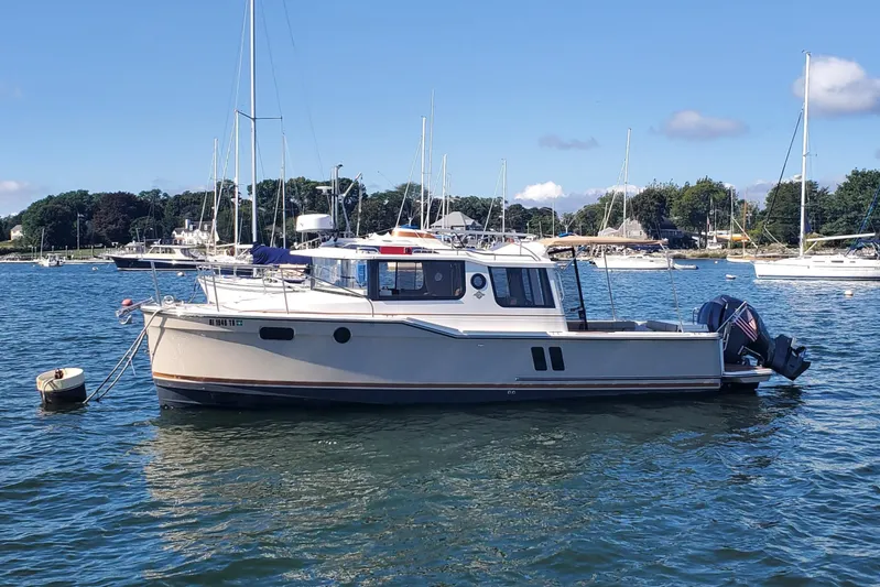 Tusen Takk Yacht Photos Pics 2024 Ranger Tugs R-27 boat anchored in a scenic harbor with sailboats.