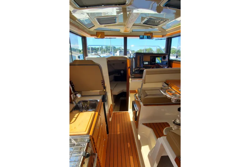 Tusen Takk Yacht Photos Pics 2024 Ranger Tugs R-27 interior with modern helm, seating, and wood finishes.
