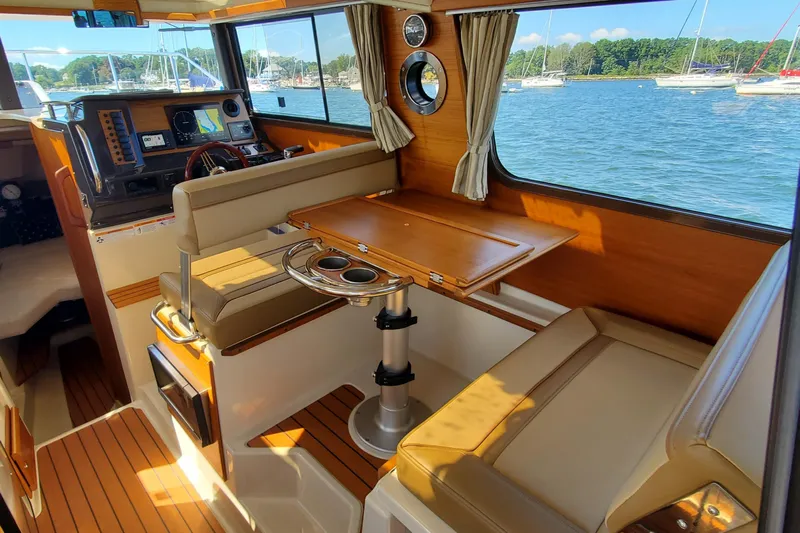 Tusen Takk Yacht Photos Pics Interior of 2024 Ranger Tugs R-27, featuring a cozy dining area with scenic window views.
