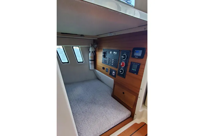 Tusen Takk Yacht Photos Pics 2024 Ranger Tugs R-27 cabin interior with control panel and fire extinguisher.