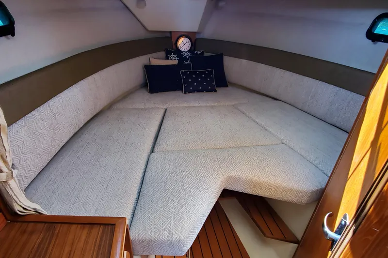 Tusen Takk Yacht Photos Pics 2024 Ranger Tugs R-27 cabin interior with cozy bedding and nautical decor.