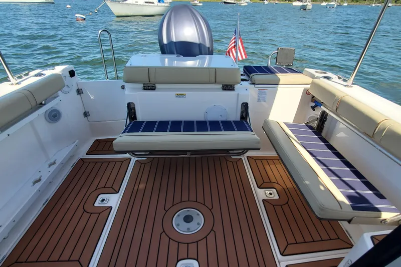 Tusen Takk Yacht Photos Pics 2024 Ranger Tugs R-27 boat interior with cushioned seating and wooden deck.