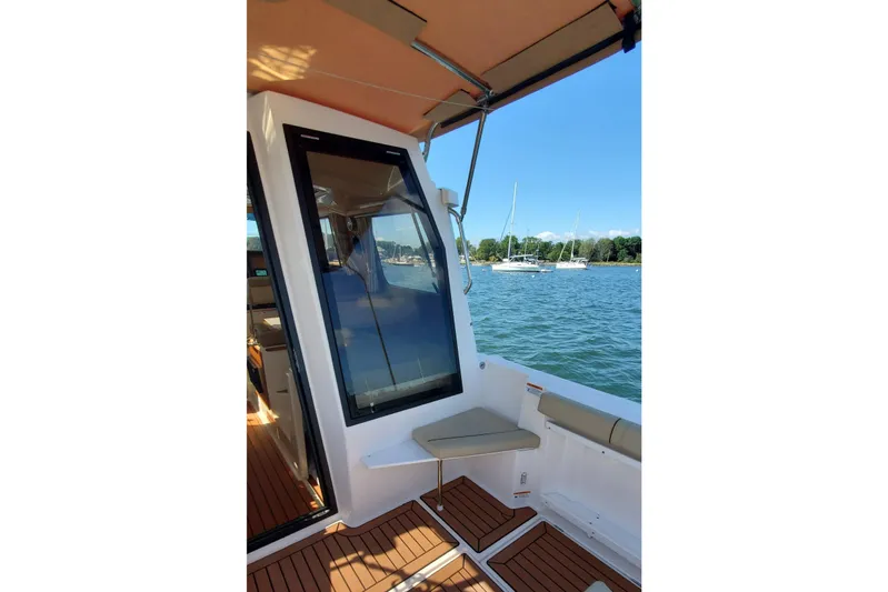 Tusen Takk Yacht Photos Pics 2024 Ranger Tugs R-27 boat interior with seating, overlooking a serene water view.