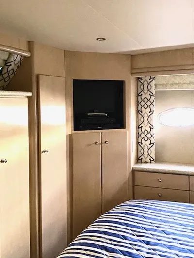 Yacht Photos Pics Interior of 1999 Carver 456 Aft Cabin Motor Yacht with TV and striped bedding.
