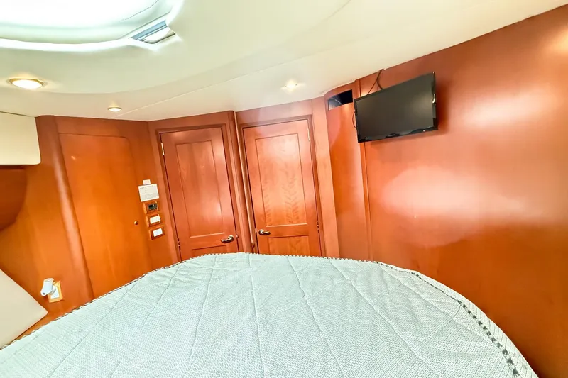 Steel Dreamin Yacht Photos Pics Interior of 2004 Silverton 48 Convertible yacht with wood paneling and mounted TV.