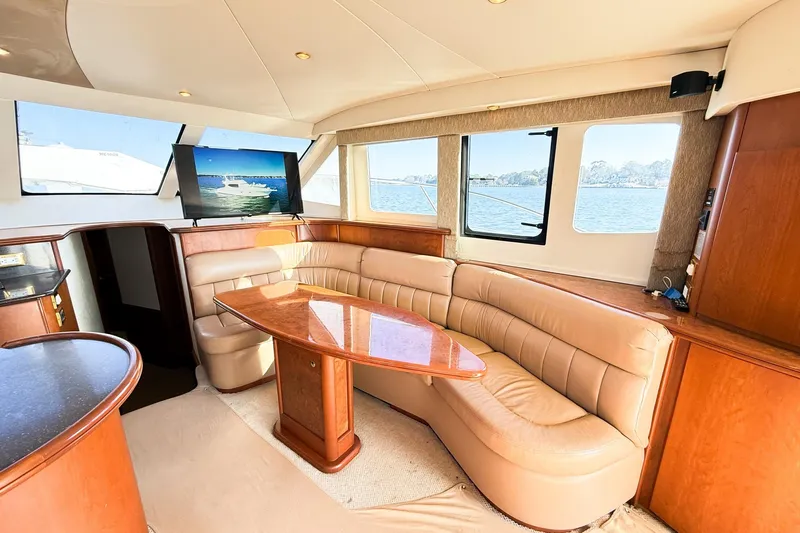 Steel Dreamin Yacht Photos Pics Luxurious interior of 2004 Silverton 48 Convertible yacht with leather seating and wooden table.