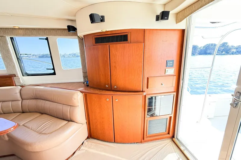Steel Dreamin Yacht Photos Pics Interior of 2004 Silverton 48 Convertible yacht with wood cabinetry and leather seating by a window.