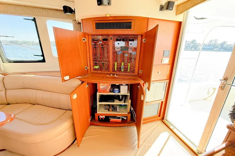 Steel Dreamin Yacht Photos Pics 2004 Silverton 48 Convertible yacht interior with open electrical panel and beige seating.