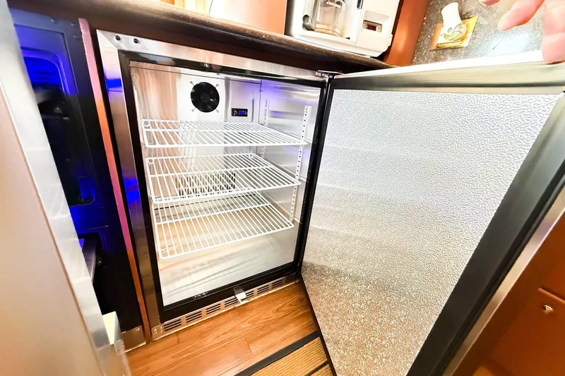 Steel Dreamin Yacht Photos Pics Open refrigerator inside 2004 Silverton 48 Convertible yacht, featuring wire shelves and modern design.