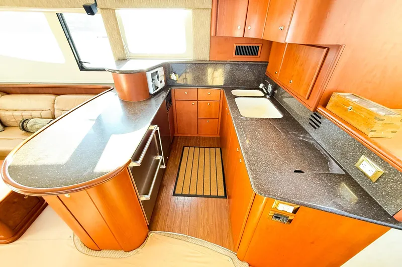 Steel Dreamin Yacht Photos Pics Luxurious kitchen interior of 2004 Silverton 48 Convertible yacht with wood cabinetry.