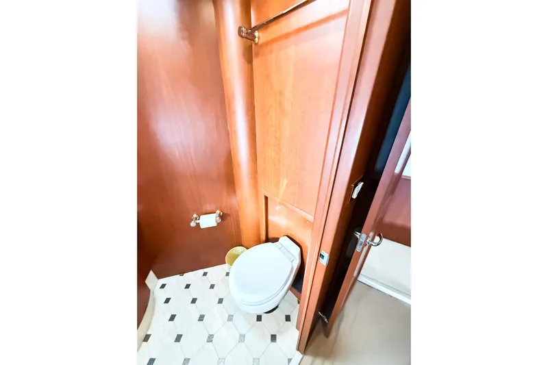 Steel Dreamin Yacht Photos Pics Bathroom interior of 2004 Silverton 48 Convertible yacht with wooden paneling and tiled floor.