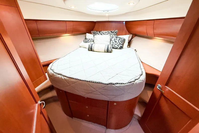 Steel Dreamin Yacht Photos Pics Luxurious cabin interior of 2004 Silverton 48 Convertible yacht with cozy bed and elegant wood finish.