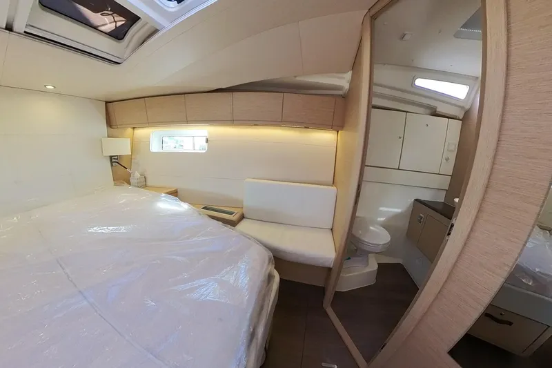  Yacht Photos Pics Luxurious interior of 2020 Jeanneau 54 yacht featuring a cozy bedroom and modern bathroom.