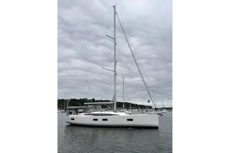  Yacht Photos Pics 2020 Jeanneau 54 sailboat on calm water under cloudy sky.