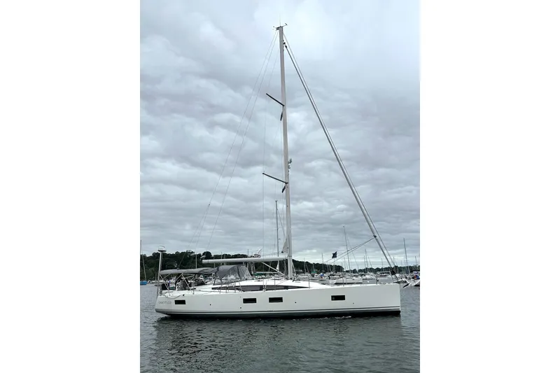  Yacht Photos Pics 2020 Jeanneau 54 sailboat on calm water under cloudy sky.
